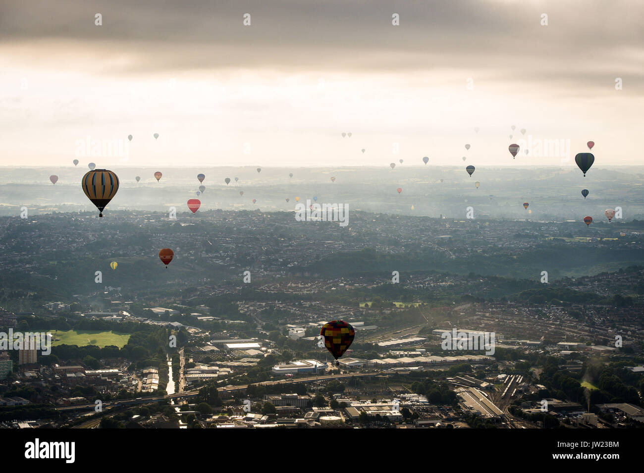 I palloni ad aria calda sorvola la città di Bristol durante la prima salita di massa, dove mongolfiere provenienti da tutto il mondo si riuniranno a Ashton Court, Bristol, a prendere parte al Bristol International Balloon Fiesta. Foto Stock