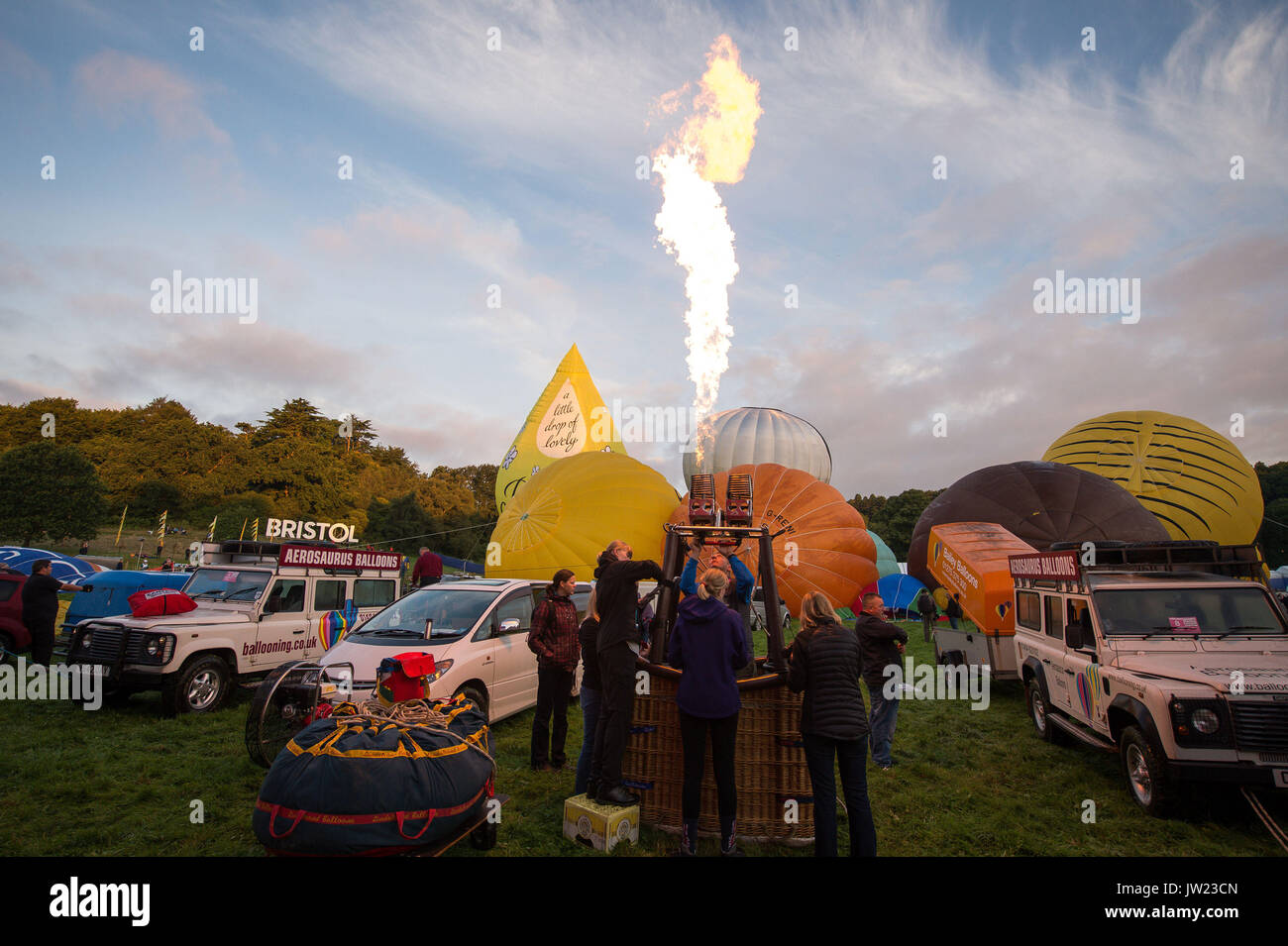 Mongolfiera equipaggi alla prova la loro bruciatori durante la prima salita di massa, dove mongolfiere provenienti da tutto il mondo si riuniranno a Ashton Court, Bristol, a prendere parte al Bristol International Balloon Fiesta. Foto Stock