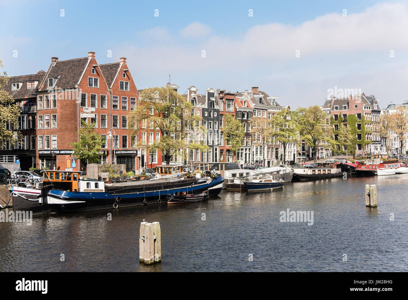 Case di Amsterdam e case galleggianti lungo il fiume Amstel. Foto Stock