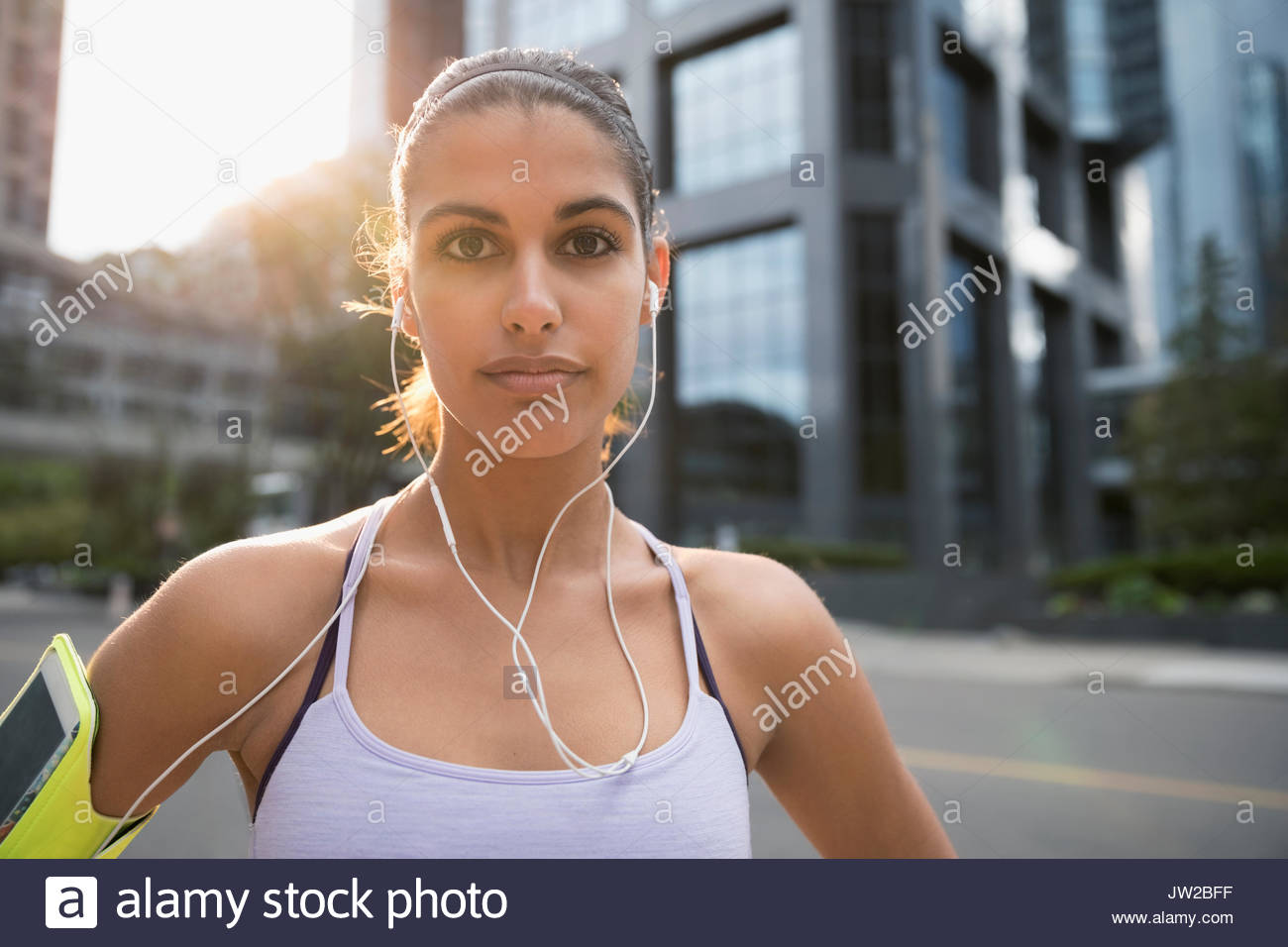 Ritratto di giovane serio femminile l'ascolto di musica con le cuffie auricolari e il lettore mp3 fascia per il braccio Foto Stock