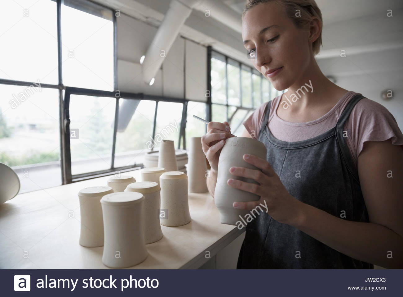 Femmina firma potter, fondelli di marcatura di argilla vasi in ceramica studio Foto Stock