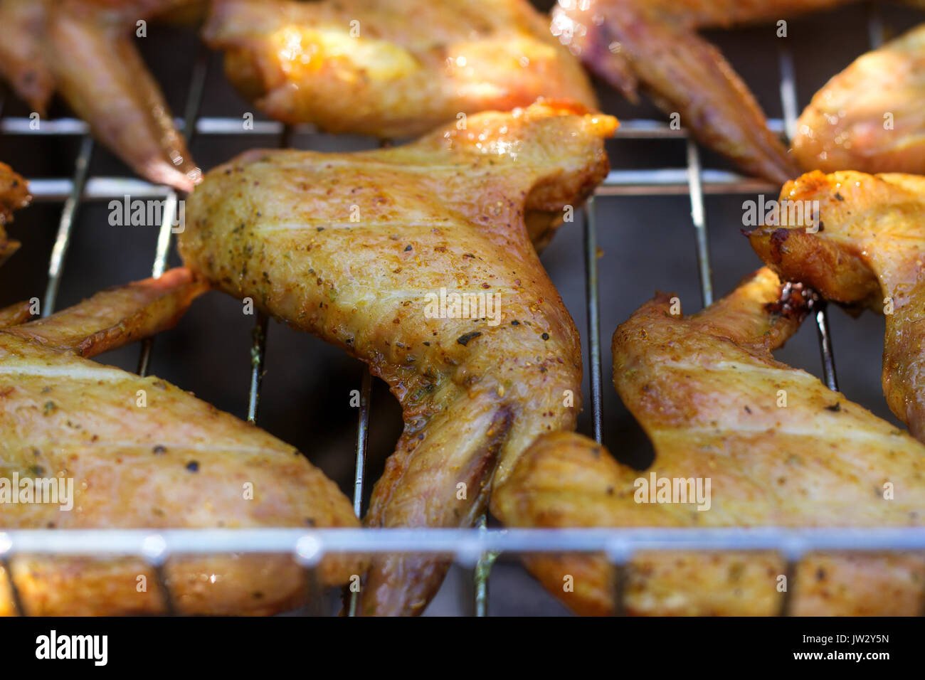 Ali di pollo su barbecue grill con il fuoco Foto Stock