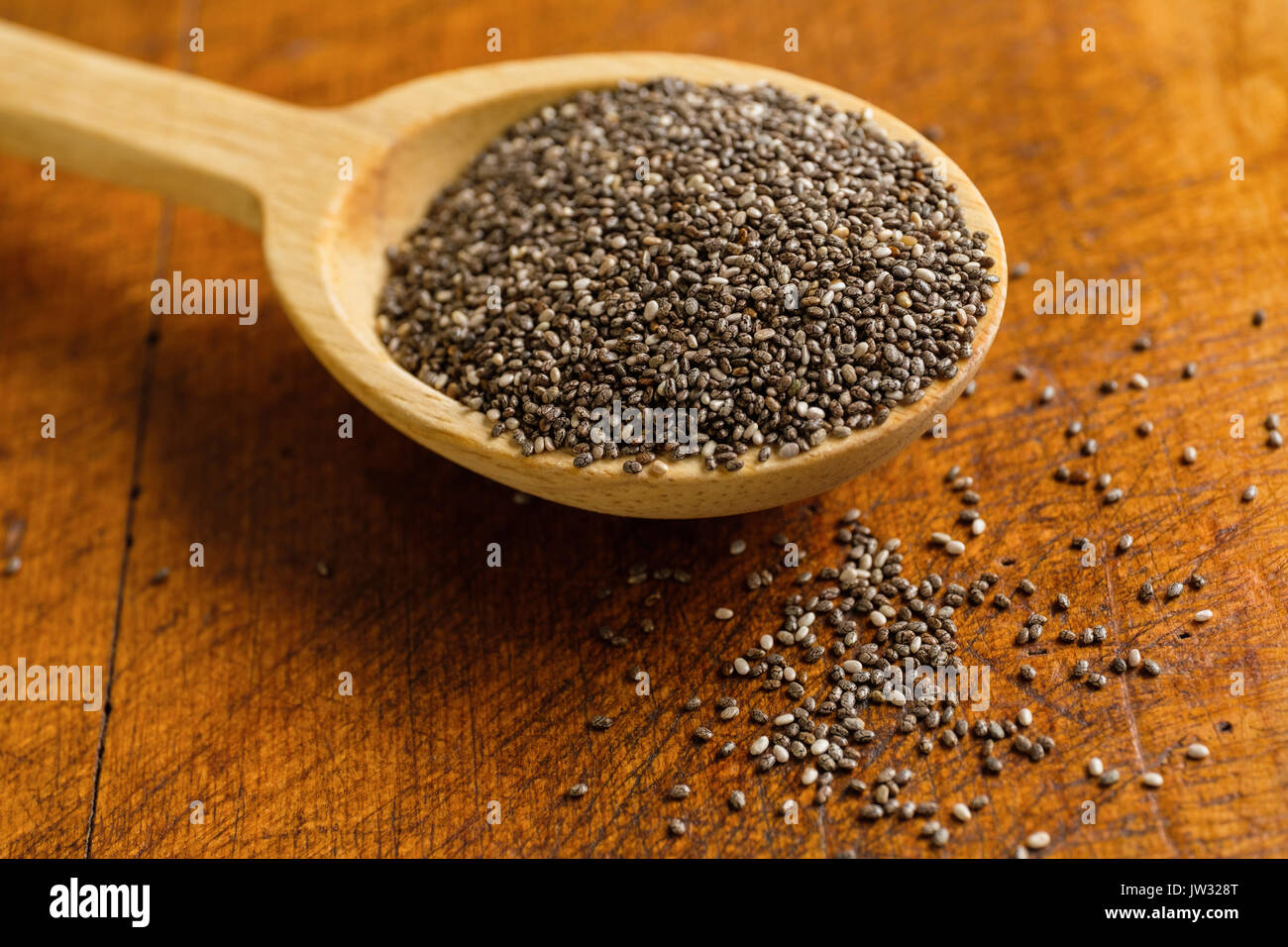 Cucchiaio di legno pieno di chia semi sulla tabella Foto Stock