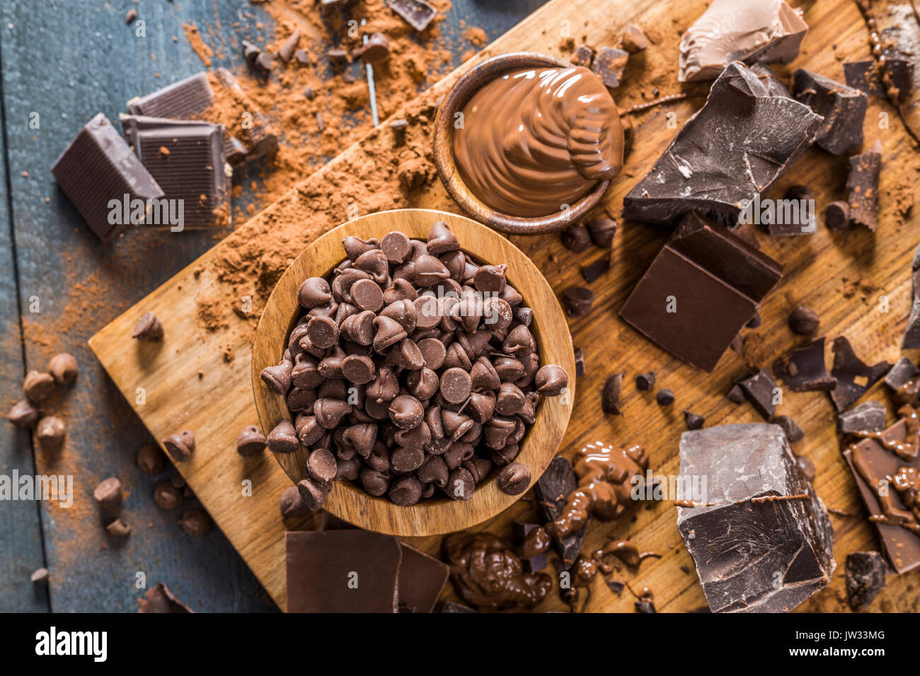 Vari pezzetti di cioccolato e cioccolato fuso sul bordo di taglio Foto Stock