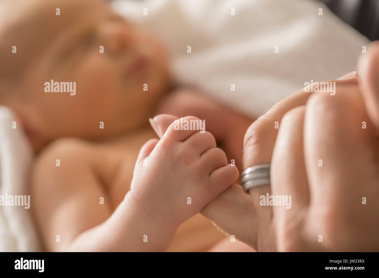 Figlio neonato (0-1 mese) tenendo il padre del dito Foto Stock