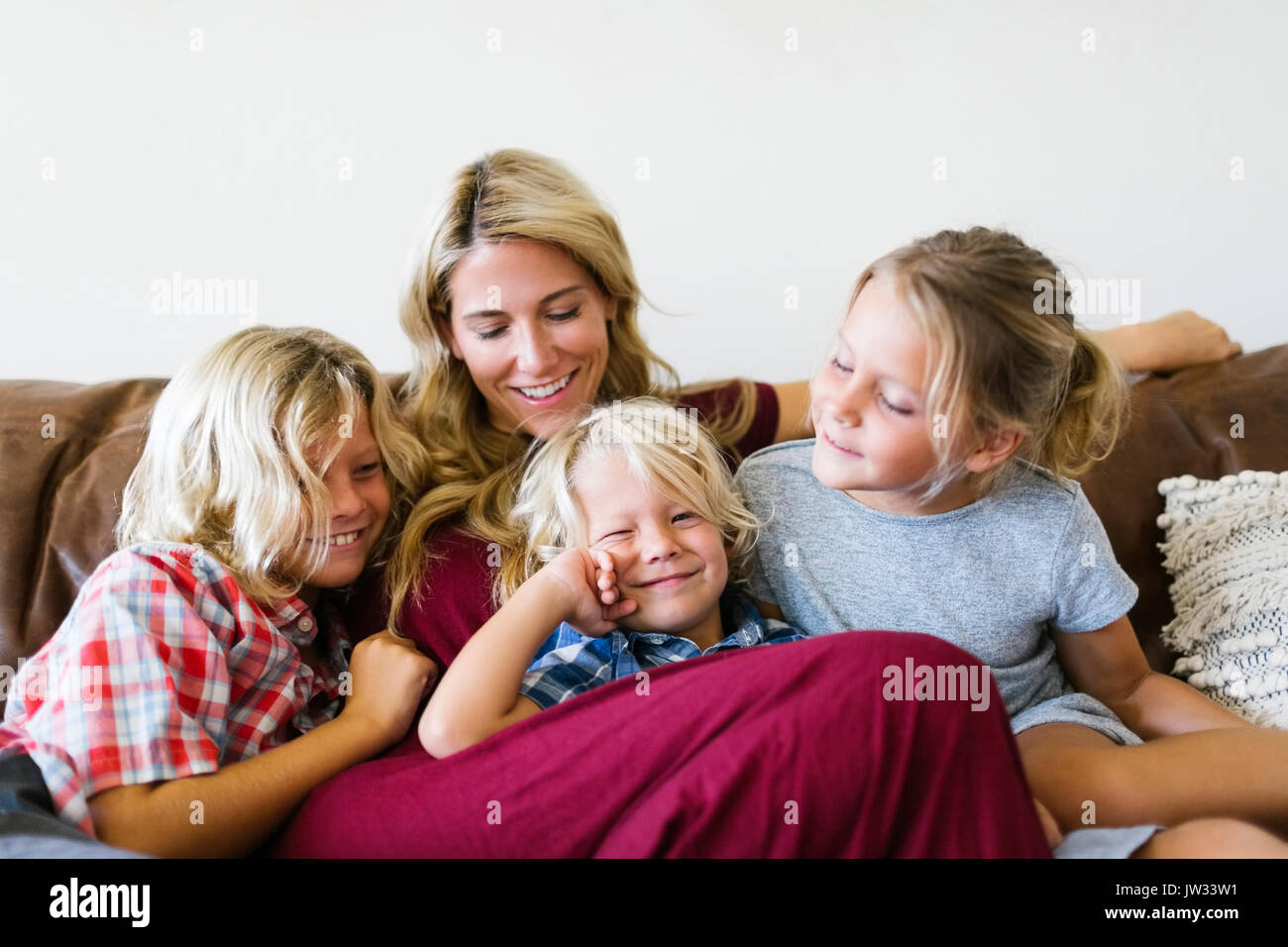 Madre e bambini (4-5, 6-7, 8-9) di appoggio in salotto Foto Stock