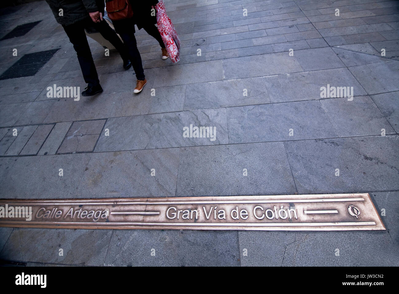 Indicazione del bronzo nel terreno indica nome della strada Prependicular alla croce di strade di Granada, Andalusia, Spagna Foto Stock