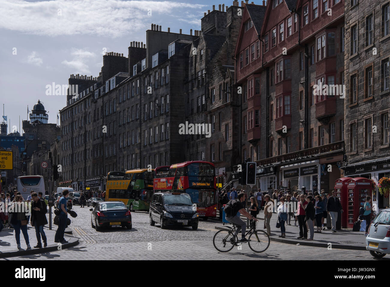 Una vivace strada immagine in estate con le persone e gli autobus del Royal Mile di Edimburgo, in Scozia. Foto Stock