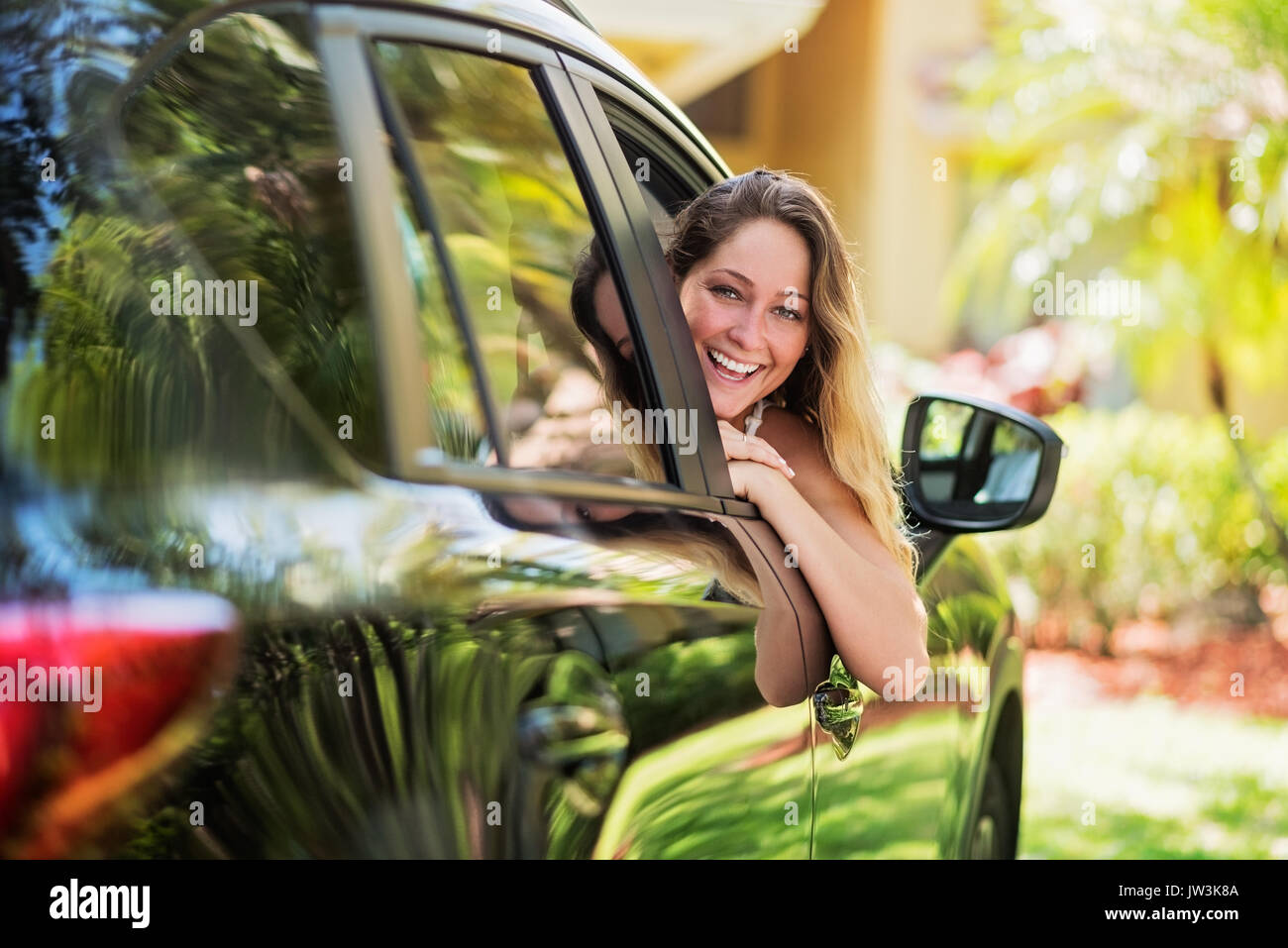Ritratto di donna guardando fuori della finestra auto Foto Stock