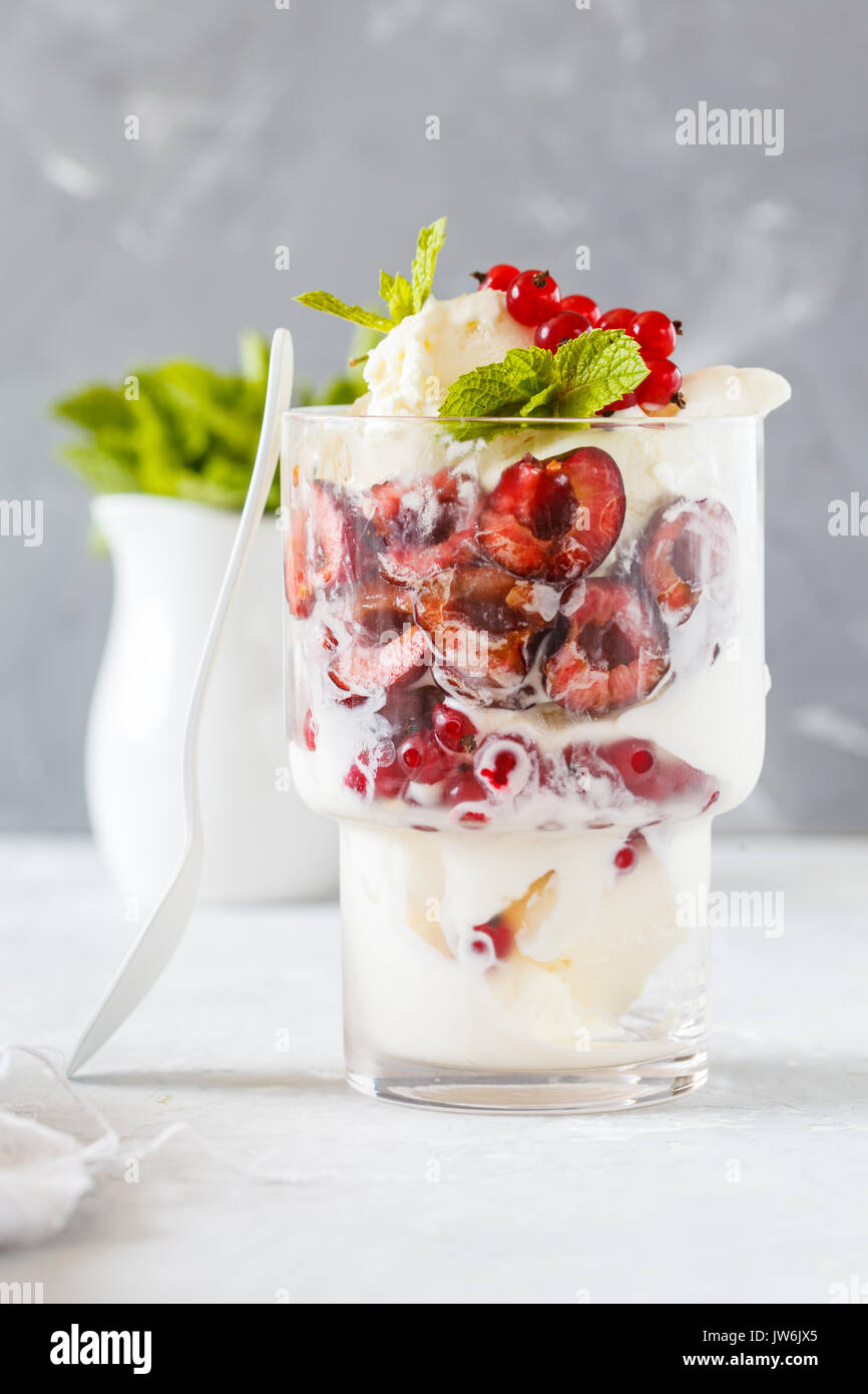 In casa di gelato alla vaniglia con frutti di bosco in un bicchiere. Amore per un sano cibo vegan concetto. Foto Stock