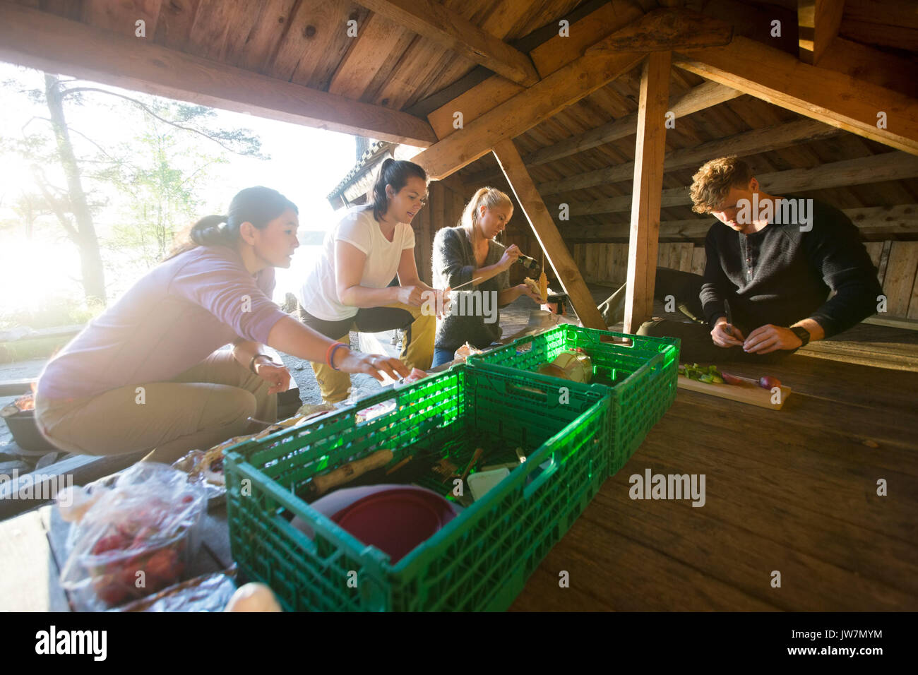 Multietnica maschio e femmina amici preparare snack in un capannone a forest Foto Stock