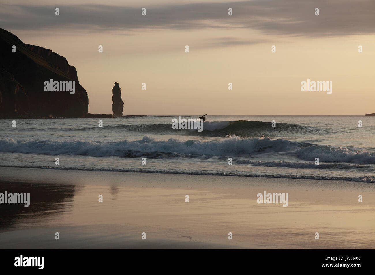 Surfer in tarda serata, la posizione è Sandwood Bay in NW Scozia. Foto Stock