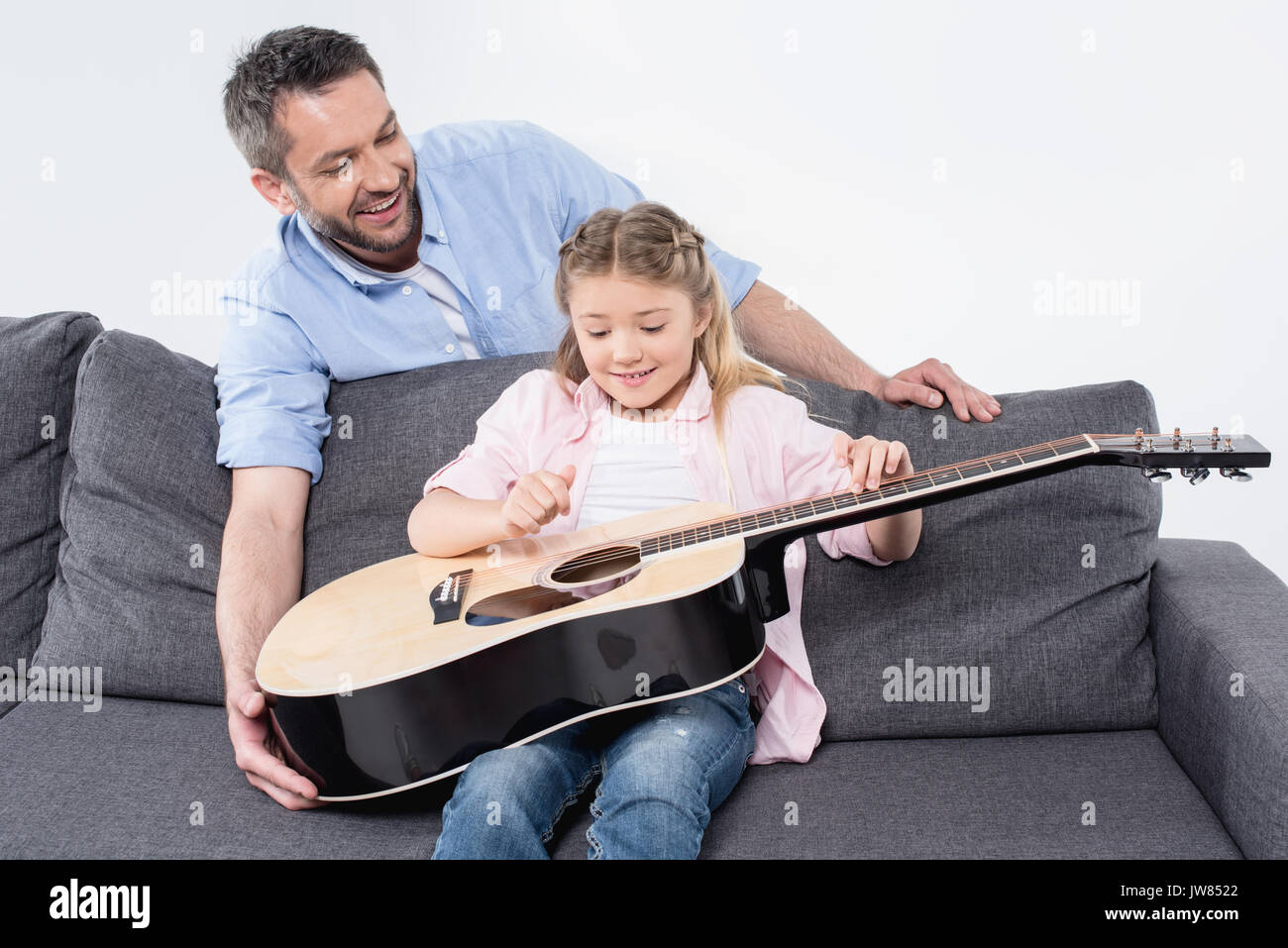 Padre Felice ad insegnare la sua adorabile figlia a giocare alla chitarra Foto Stock