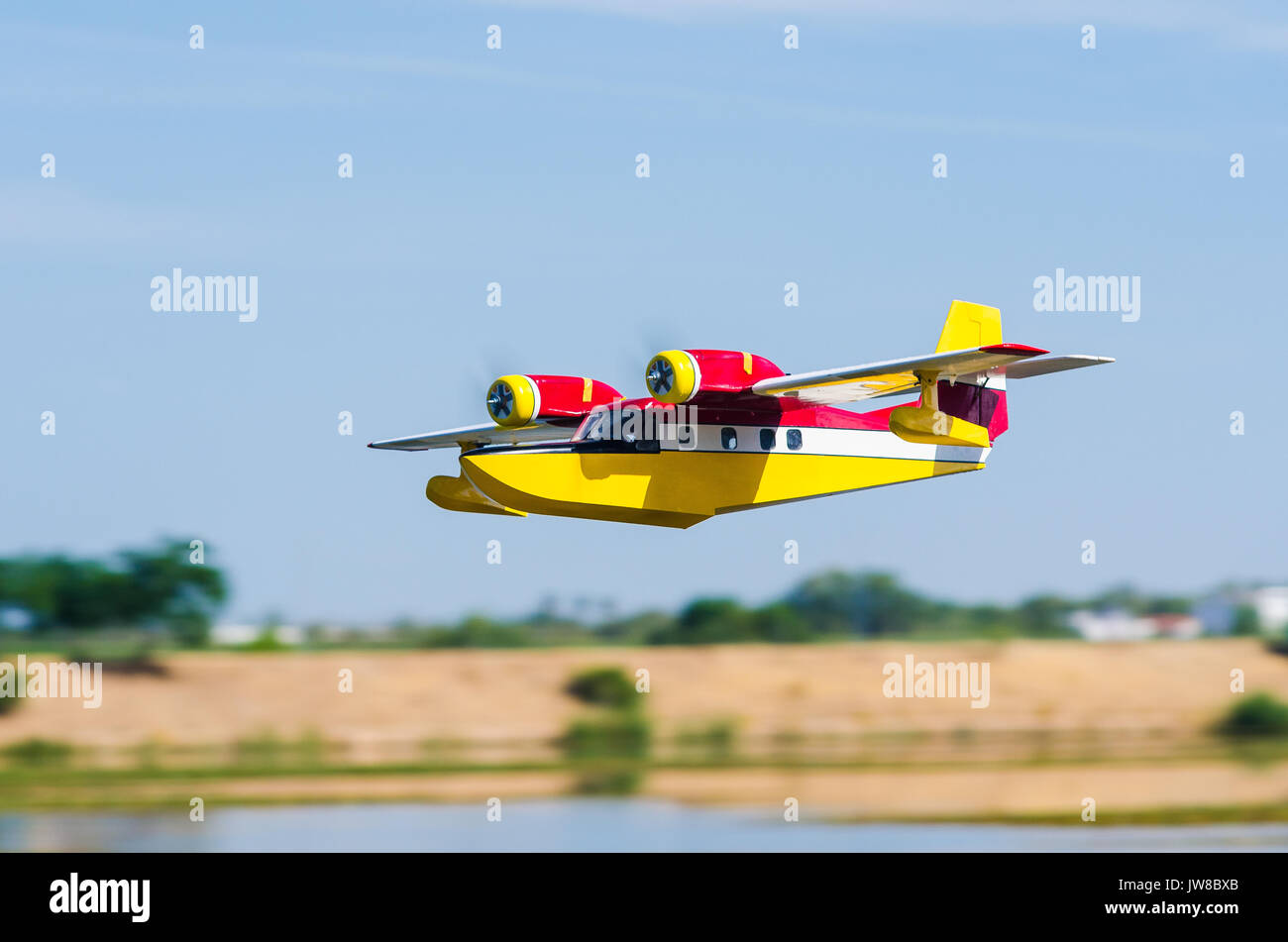Radio modello controllato idrovolante a volare su un bel giorno nuvoloso oltre il fiume Guadiana in Badajoz, Estremadura, Spagna Foto Stock