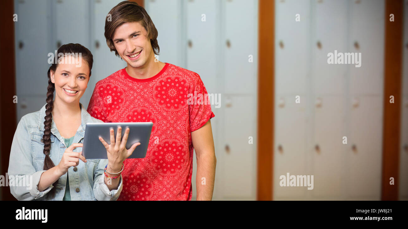 Sorridendo i compagni di scuola con i tablet pc contro armadietti chiusi in una fila presso il college Foto Stock