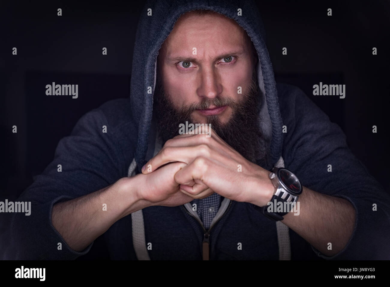 Riflessivo executive in felpa con cappuccio seduti in ufficio Foto Stock
