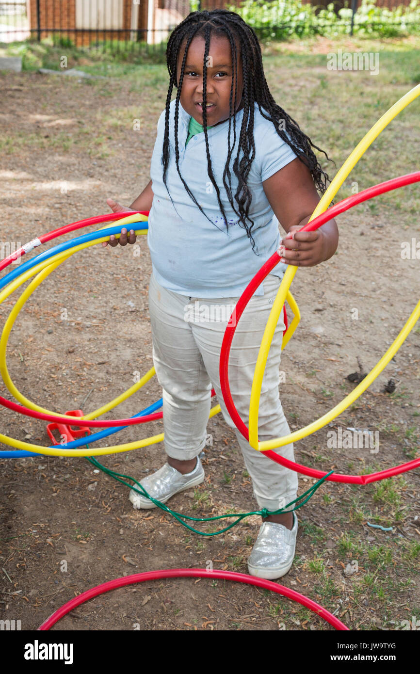 Charlotte, North Carolina - una ragazza con cerchi il parco giochi del dopo la scuola programma presso il centro di Betlemme. Il Centro serve a basso reddito fami Foto Stock
