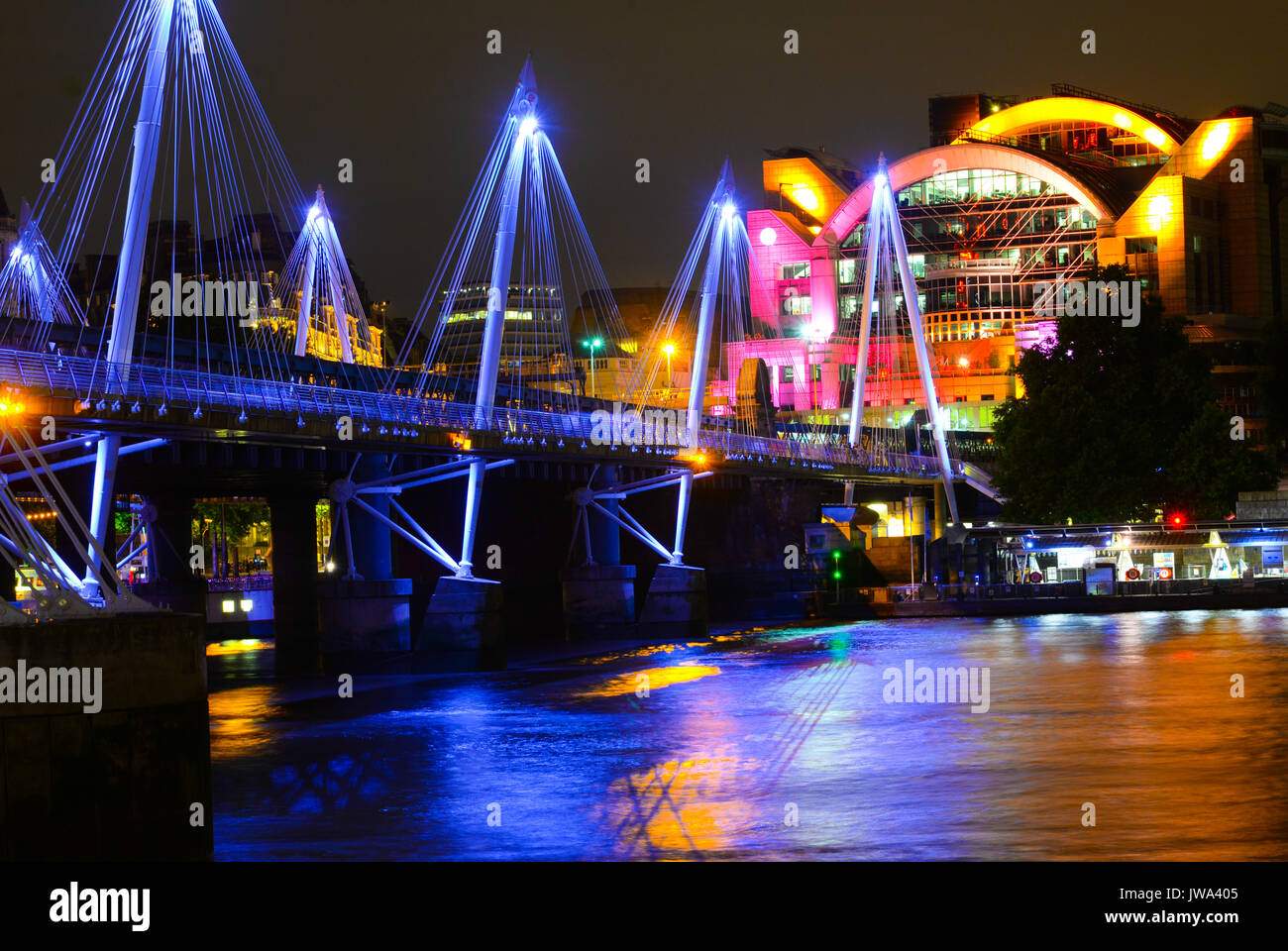 La stazione di Charing Cross durante la notte e a Hungerford Bridge e il Golden Jubilee ponti che attraversano il Tamigi Foto Stock