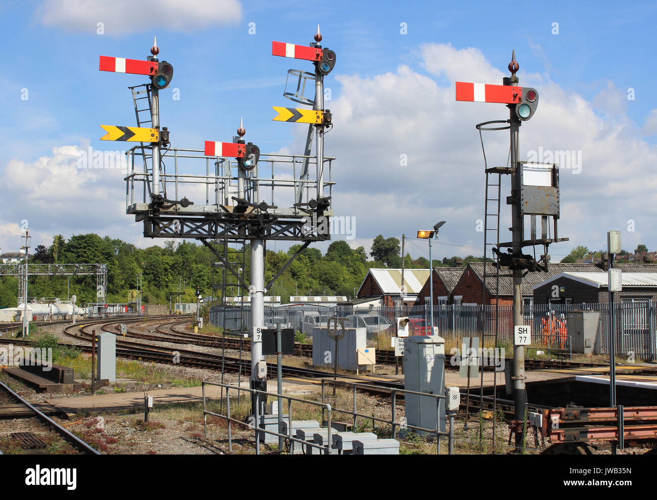 Set di semaforo segnali su un cavalletto e un unico segnale in corrispondenza di una estremità di Worcester Shrub Hill stazione ferroviaria visto contro principalmente un cielo blu. Foto Stock