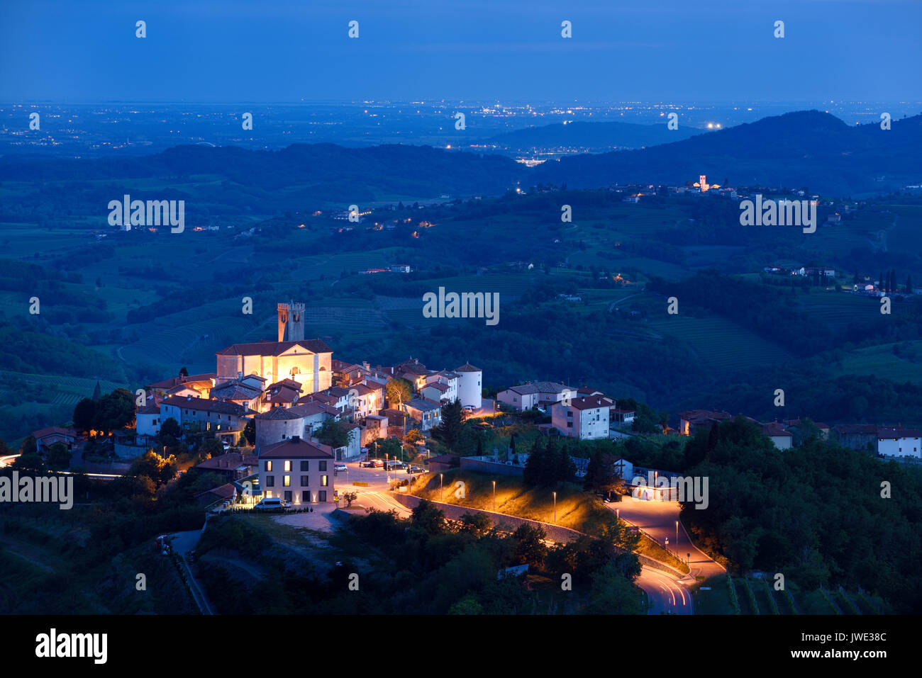 Patrimonio culturale monumento medievale borgo collinare di Brda Smartno Slovenia al tramonto con la chiesa di San Martino, Medana e Italia a distanza Foto Stock