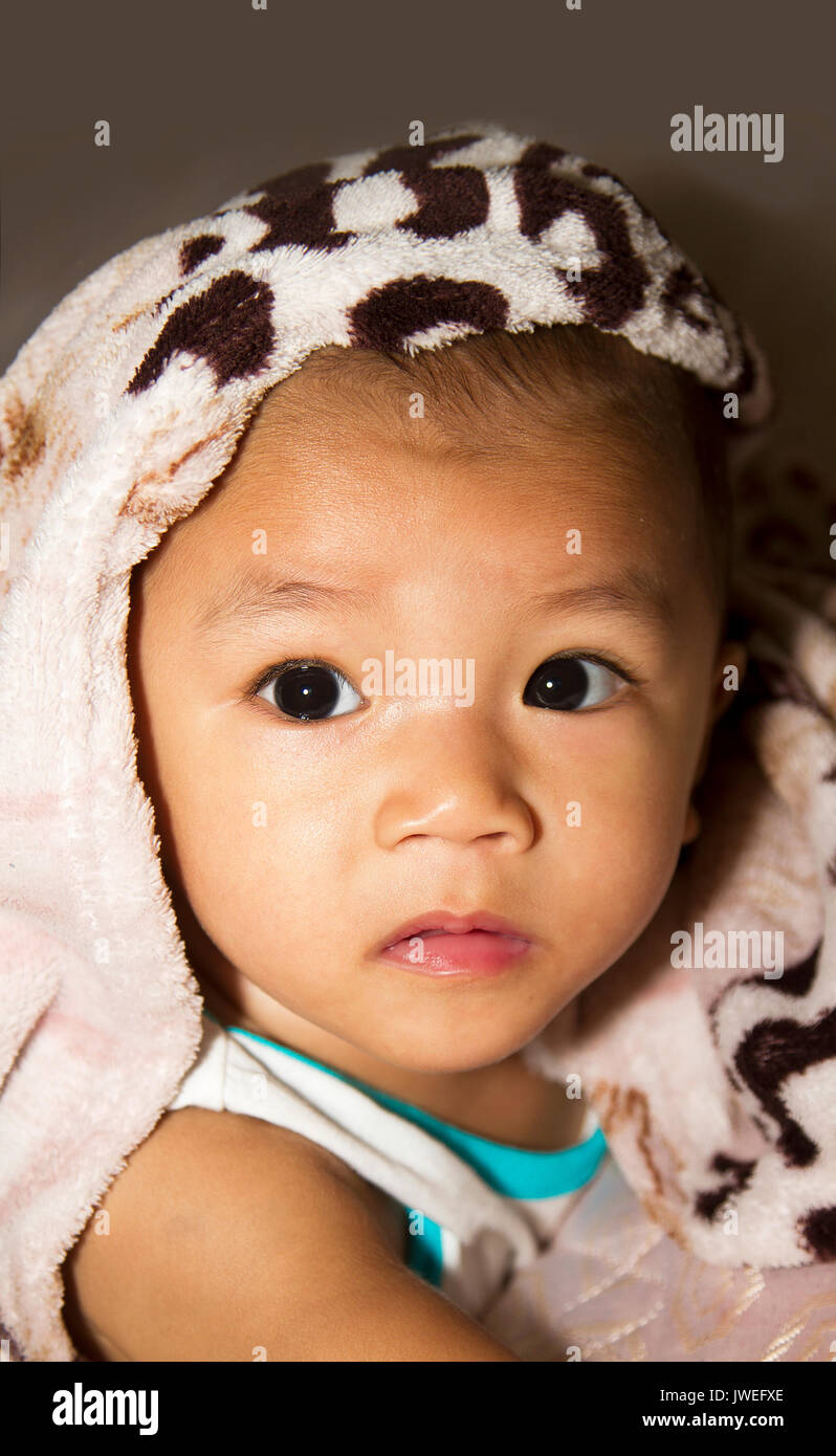 Carino stare di un bel bambino di etnia asiatica Foto Stock