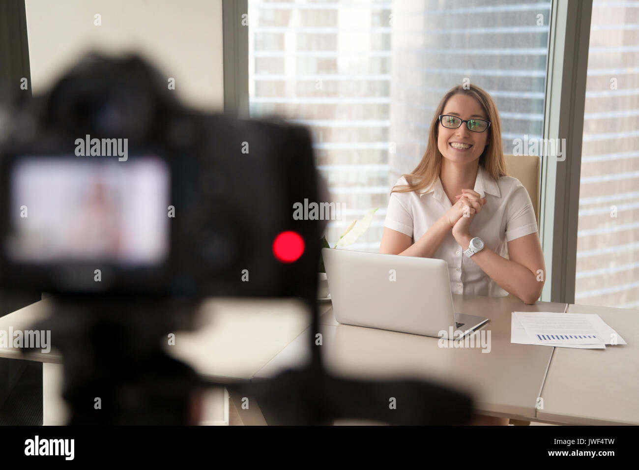 Sorridente imprenditrice parlando sulla fotocamera, lady business di registrazione Foto Stock