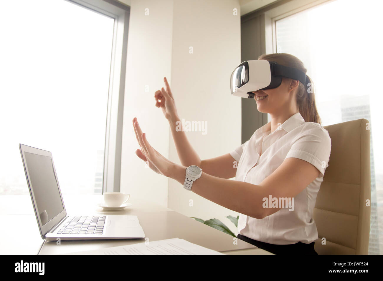 Imprenditrice eccitato in realtà virtuale bicchieri cercando di toccare Foto Stock