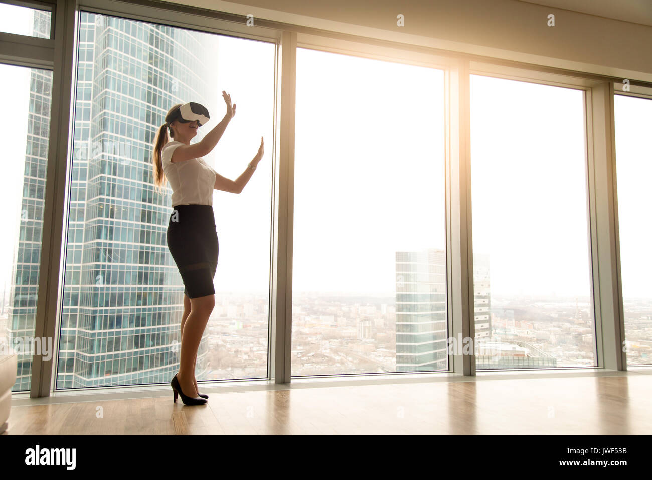 Emozionato imprenditrice che indossa la cuffia esplorare vr in piedi vicino Foto Stock