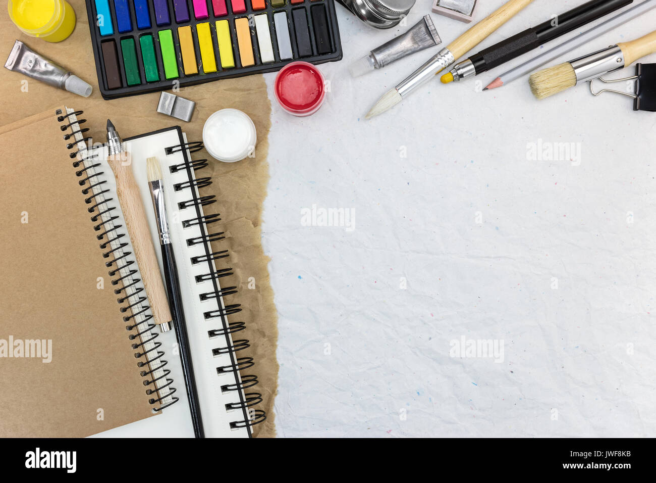 Diversi strumenti di disegno: sketchbook, acquerello, pennelli, colored  chalks, tempera, matite su carta riciclata in background Foto stock - Alamy