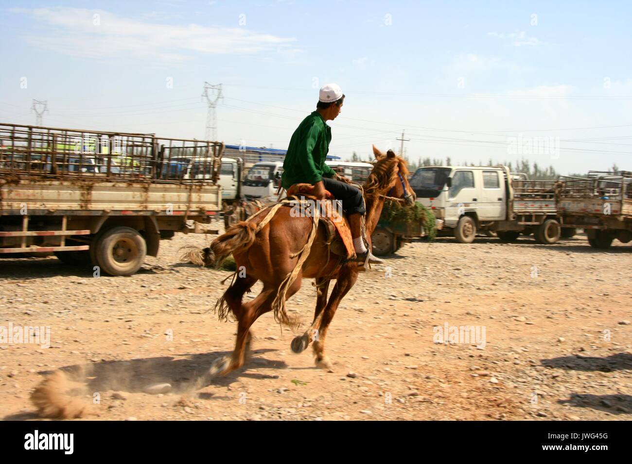 L'uomo racing un cavallo a Kashgar mercato di animali per vedere se lui vuole acquistarlo Foto Stock