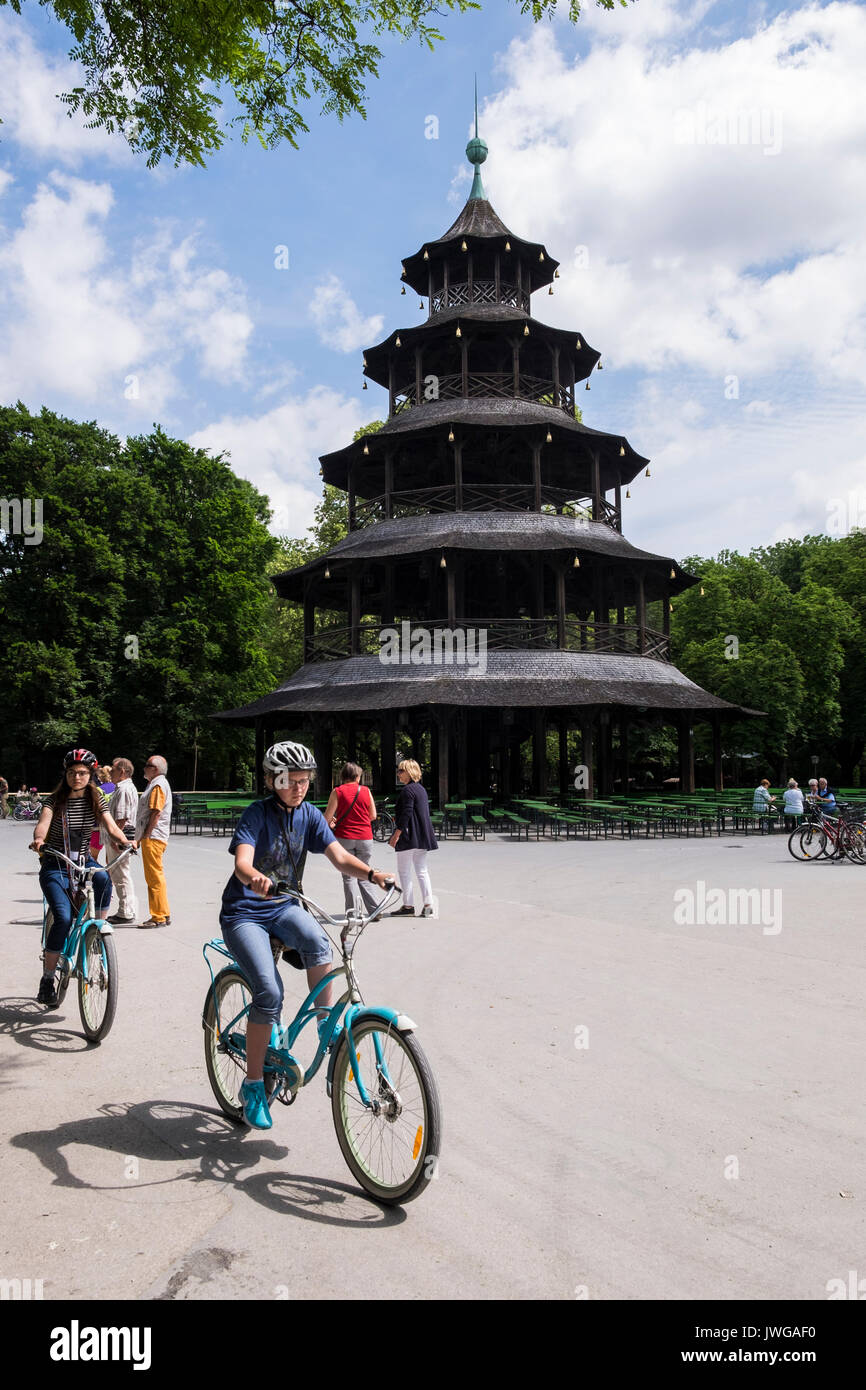 Torre cinese nell'Englischer Garten, il Giardino Inglese park, con i ciclisti, Monaco di Baviera, Germania Foto Stock
