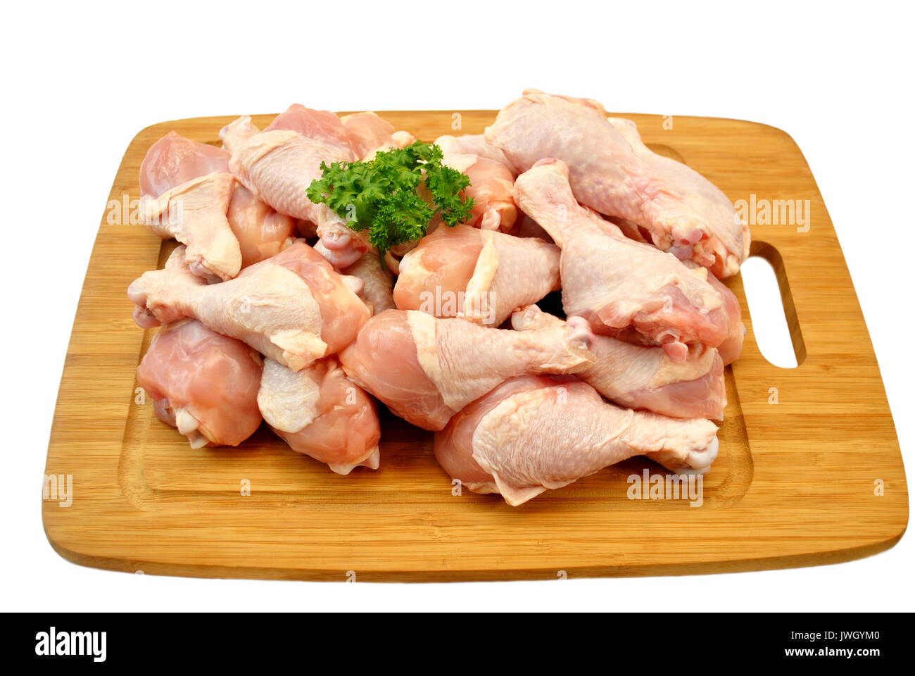 Crudo fresco di cosce di pollo su un tagliere di legno Foto Stock