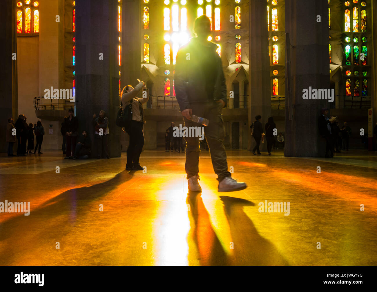 Sera La luce del sole è in arrivo attraverso le finestre verniciate della facciata occidentale di La Sagrada Familia di Barcellona cattedrale che è affollata di turisti Foto Stock