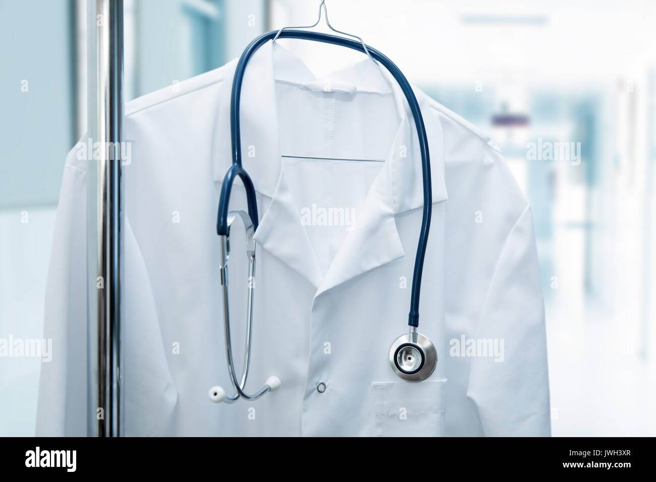 Posto di lavoro vacante - bianco medico coat su appendiabiti in ospedale in corridoio Foto Stock