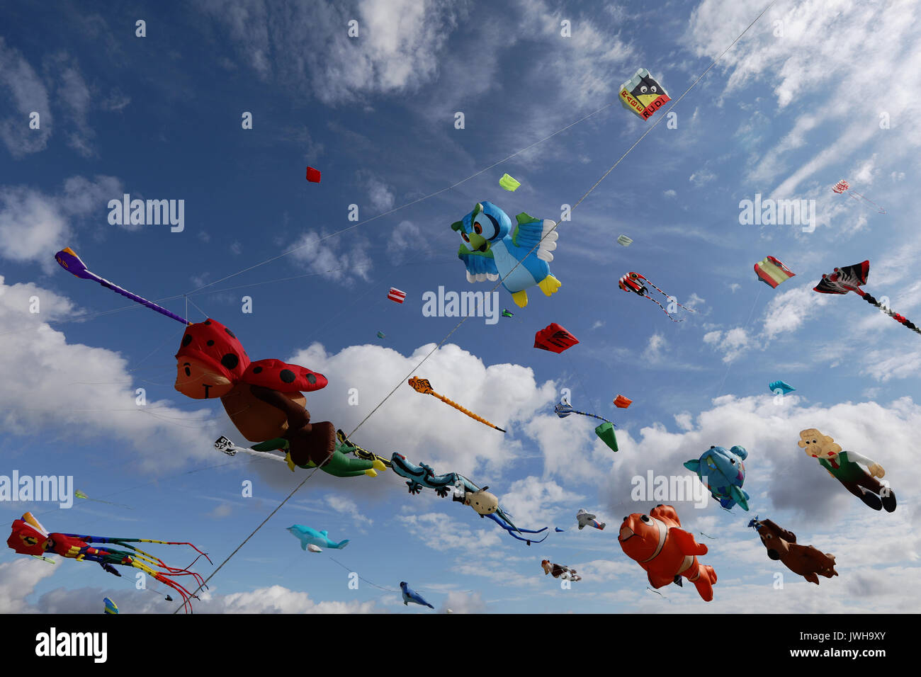 Southsea, Regno Unito. 12 Ago, 2017. La Spinnaker Tower sorge dietro centinaia di aquiloni volare a Portsmouth International Kite Festival, Sabato 12 Agosto, 2017. Perfette condizioni climatiche di vento leggero e le magie di sole significa ideali aquiloni. La festa prosegue la domenica. Credito: Luca MacGregor/Alamy Live News Foto Stock