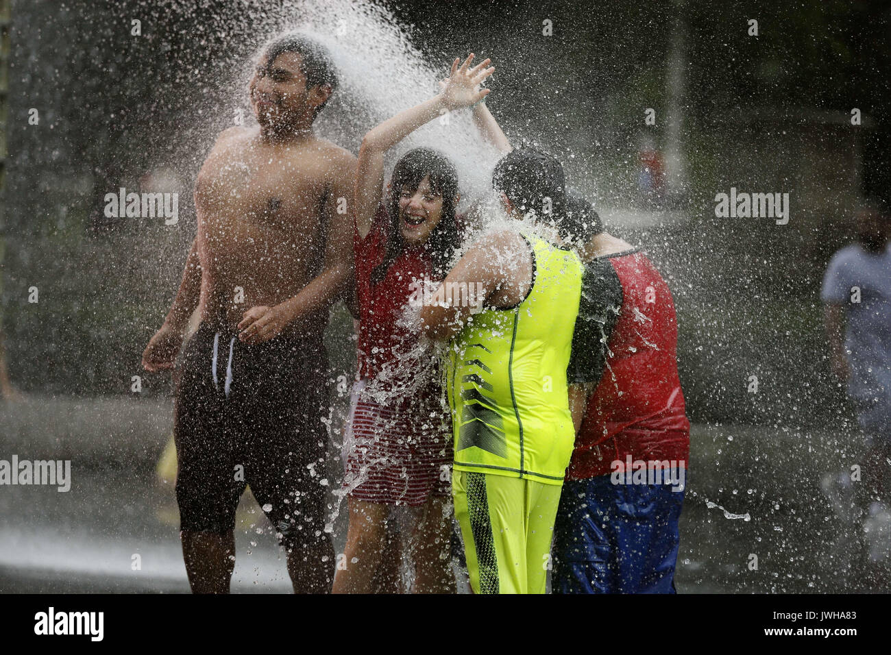 Chicago, Stati Uniti d'America. 11 Ago, 2017. Persone giocare presso il Crown Fontana nel Millennium Park di Chicago del centro, gli Stati Uniti, il 11 agosto, 2017. Fontana di corona è un lavoro interattivo di arte pubblica e scultura video featured in Chicago's Millennium Park. La fontana è composta da un granito nero piscina riflettente posizionato tra una coppia di vetro torri in mattoni con display a LED per mostrare i video digitali sulle loro facce interne. Credito: Wang Ping/Xinhua/Alamy Live News Foto Stock