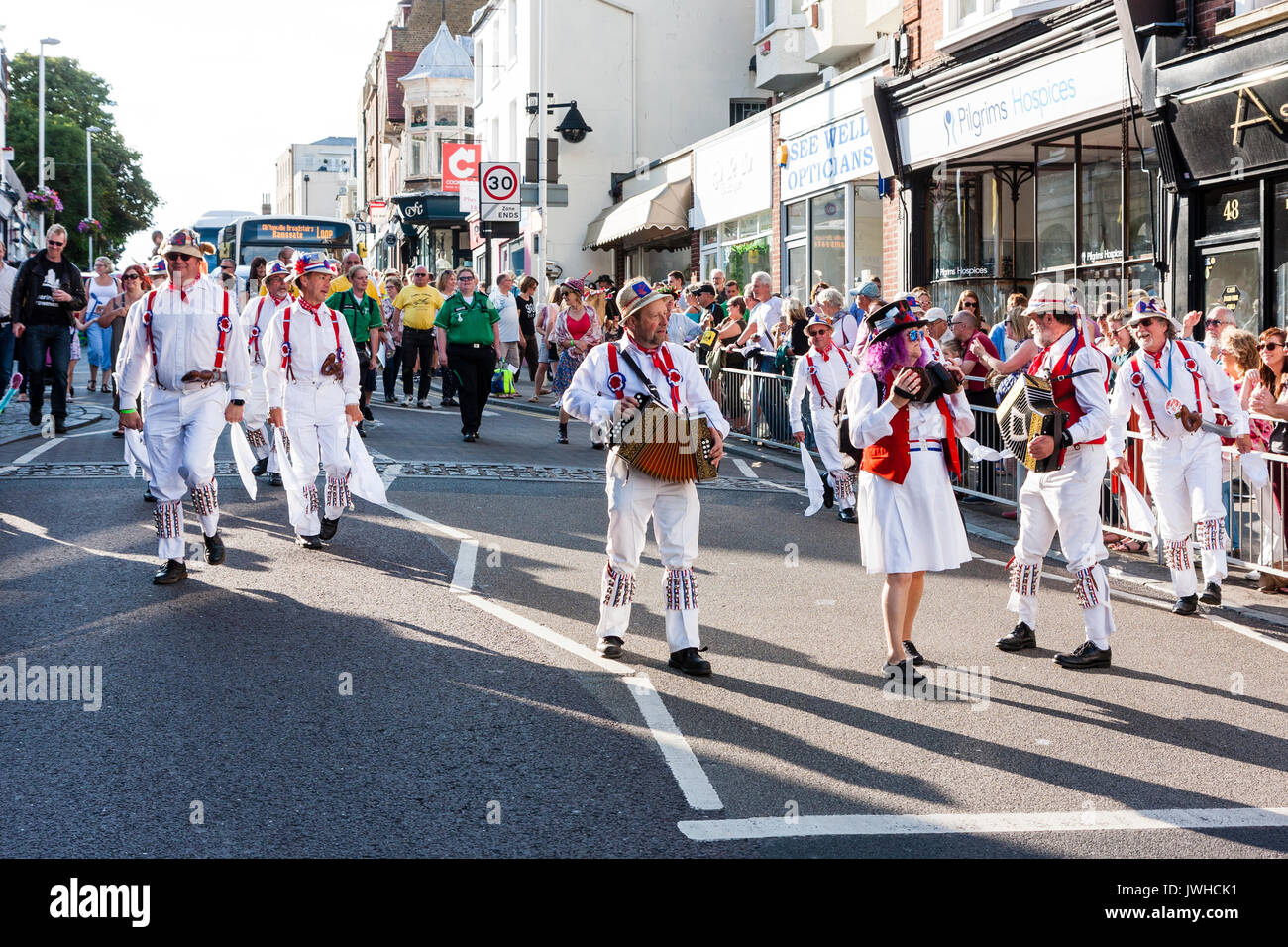 Tradizionale ballerini folk, Hartley Morris uomini, piombo da fisarmonicisti, marciare lungo Broadstairs High Street durante la sfilata nell'annuale Settimana della Musica Folk Festival. Foto Stock