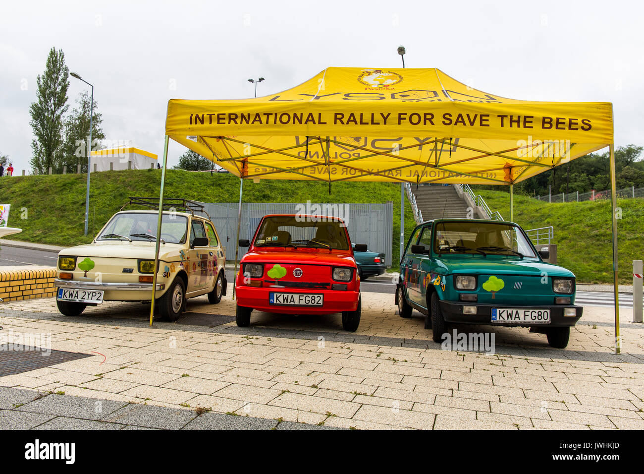 Bielsko-Biala, Polonia. 12 Ago, 2017. International Automotive fiere - Motorshow Bielsko-Biala. Tre fiat 126p (polacco - maluch) dipinta in fiori parcheggiato sotto Ombrello giallo e la promozione di un rally Internazionale per salvare le api. Credito: Lukasz Obermann/Alamy Live News Foto Stock