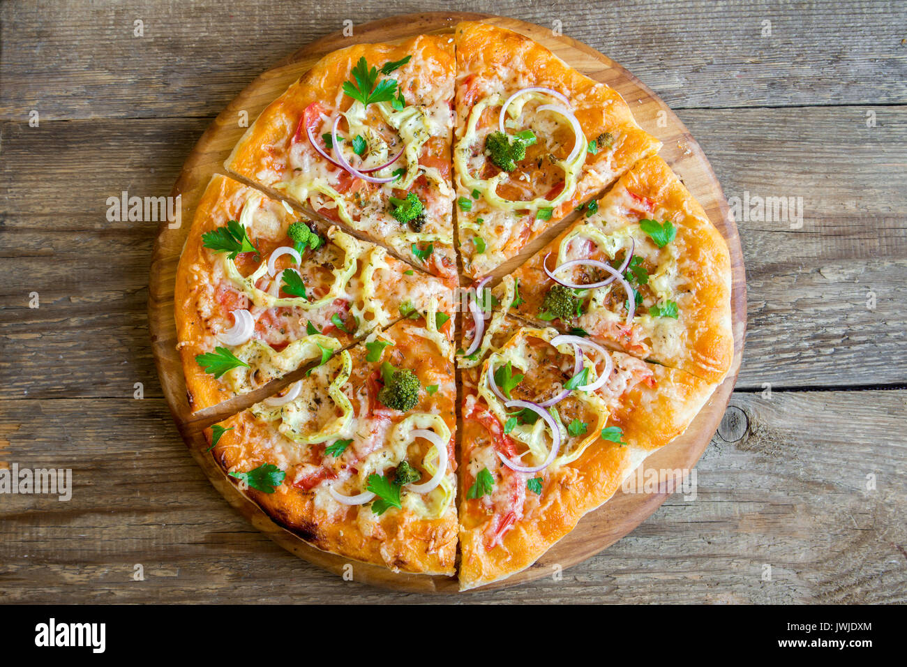 Pizza vegetariana su legno rustico sfondo. La Pizza italiana con verdure e formaggio vicino. Foto Stock
