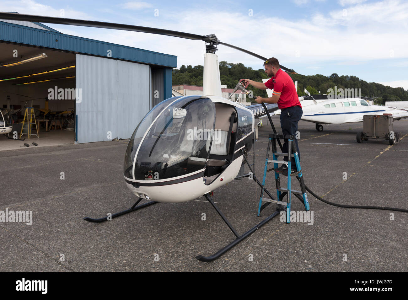 L'uomo il rifornimento Robinson R22 elicottero, Boeing Field, Seattle, Stati Uniti d'America Foto Stock