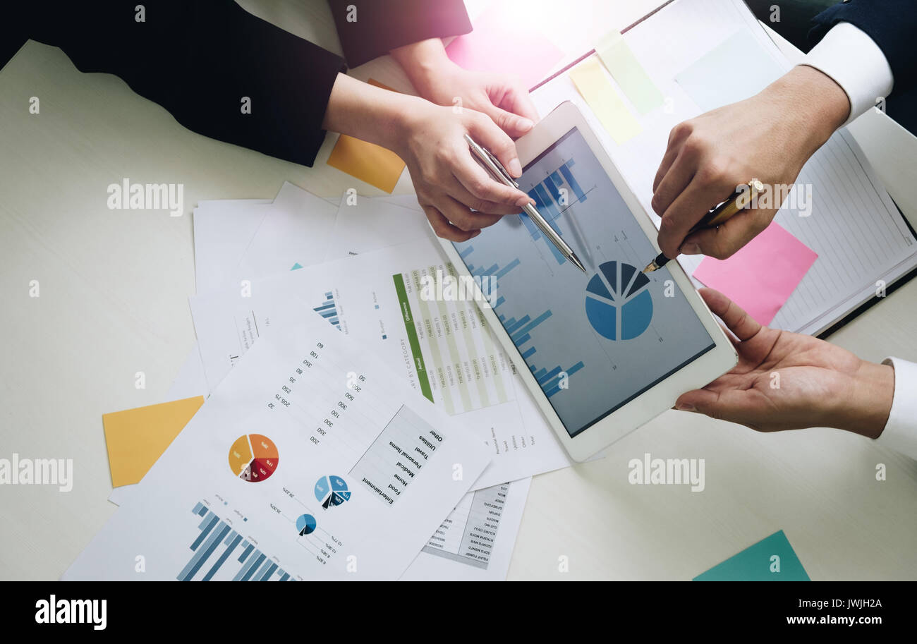 Il team Aziende le mani al lavoro con il piano finanziario, sale riunioni, di discussione, di scambio di opinioni con la compressa sulla scrivania in ufficio, vista Top Shot. Foto Stock