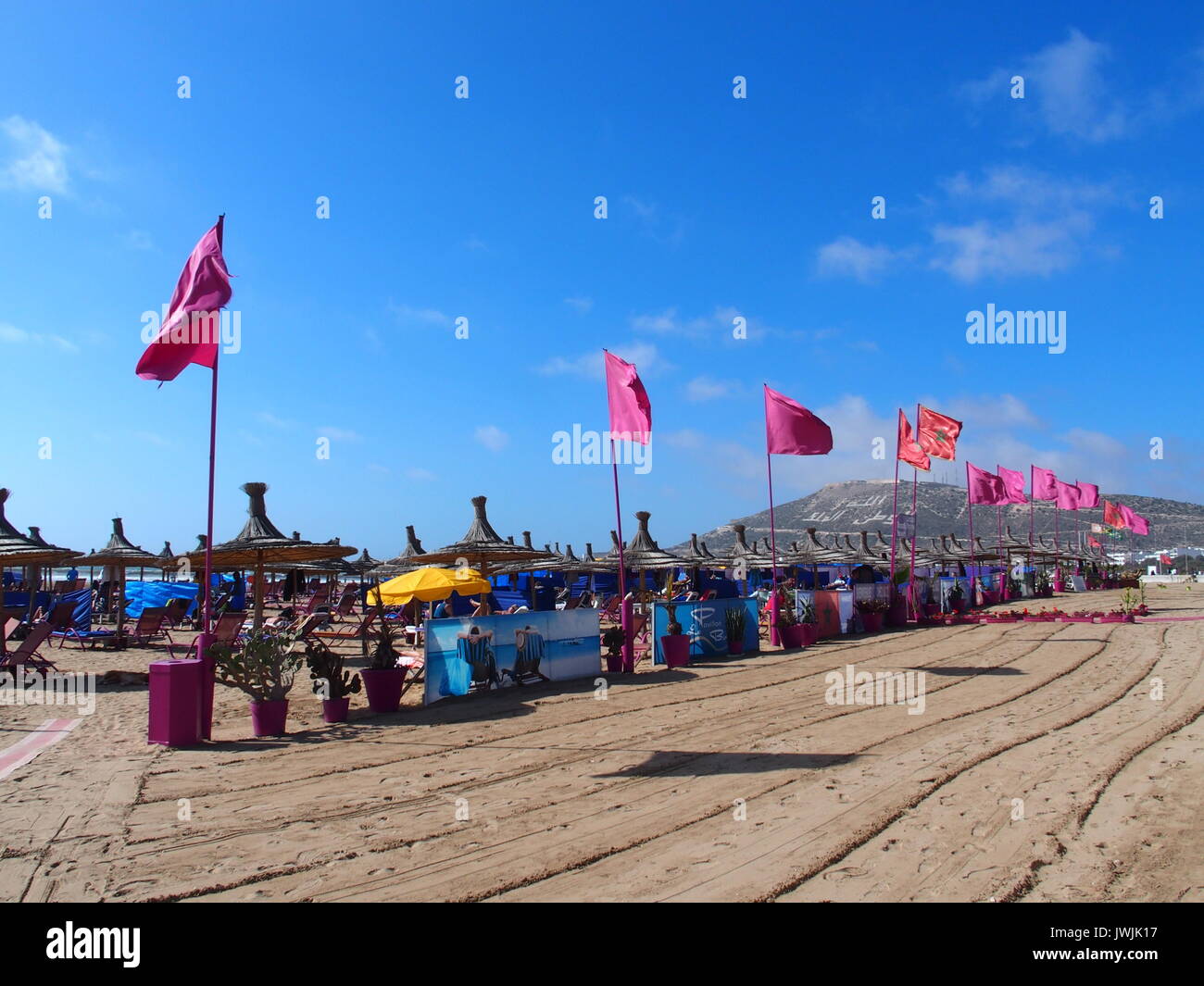 AGADIR, Marocco Europa in febbraio 2017: bandiere rosse sulla spiaggia nella città di viaggio con cielo blu chiaro in caldo e soleggiato giorno d'inverno. Foto Stock
