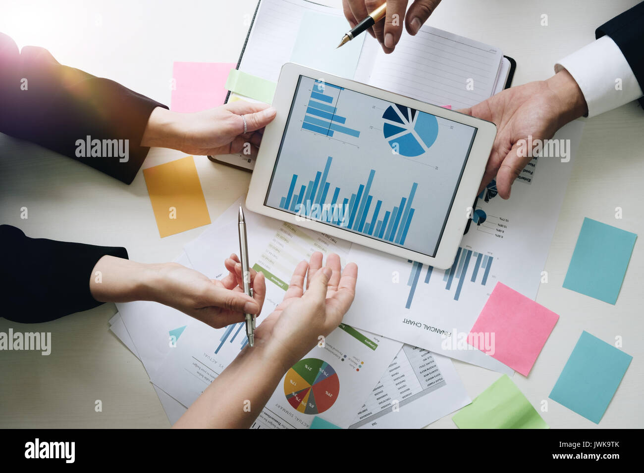 Il team Aziende le mani al lavoro con il piano finanziario, sale riunioni, discussione, brainstrom con la compressa sulla scrivania in ufficio, vista Top Shot. Foto Stock