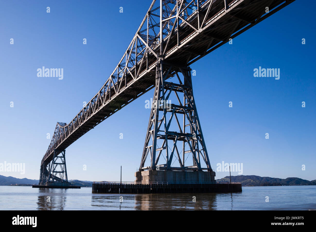 Un ponte in acciaio su acqua nel pomeriggio in una giornata di sole con cielo blu Foto Stock