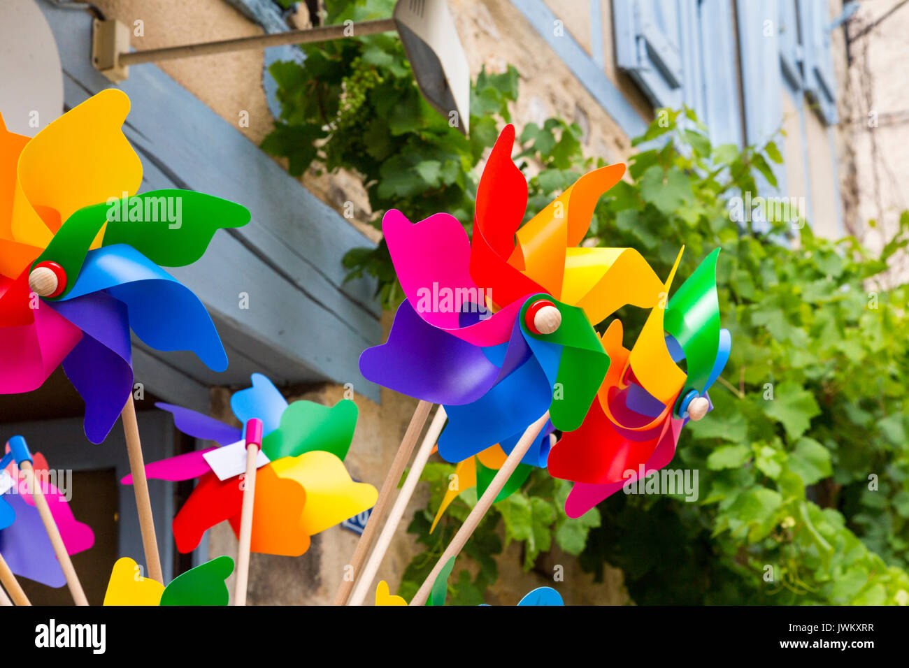 Colorati giocattoli del vento contro un vecchio muro ang vitigno. Foto Stock