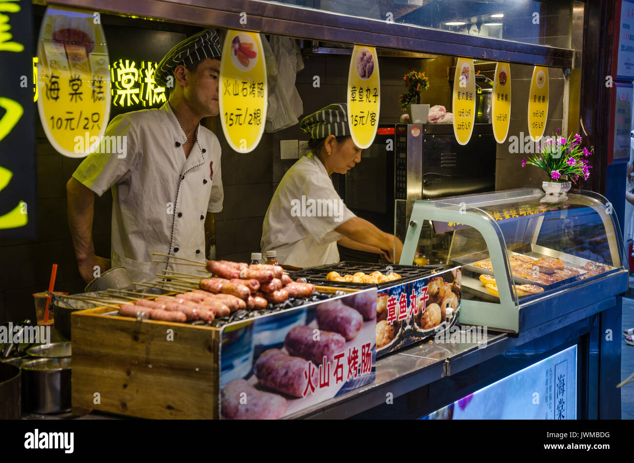 Un venditore ambulante a Shanghai in Cina la vendita di cibo appena cucinato. Foto Stock