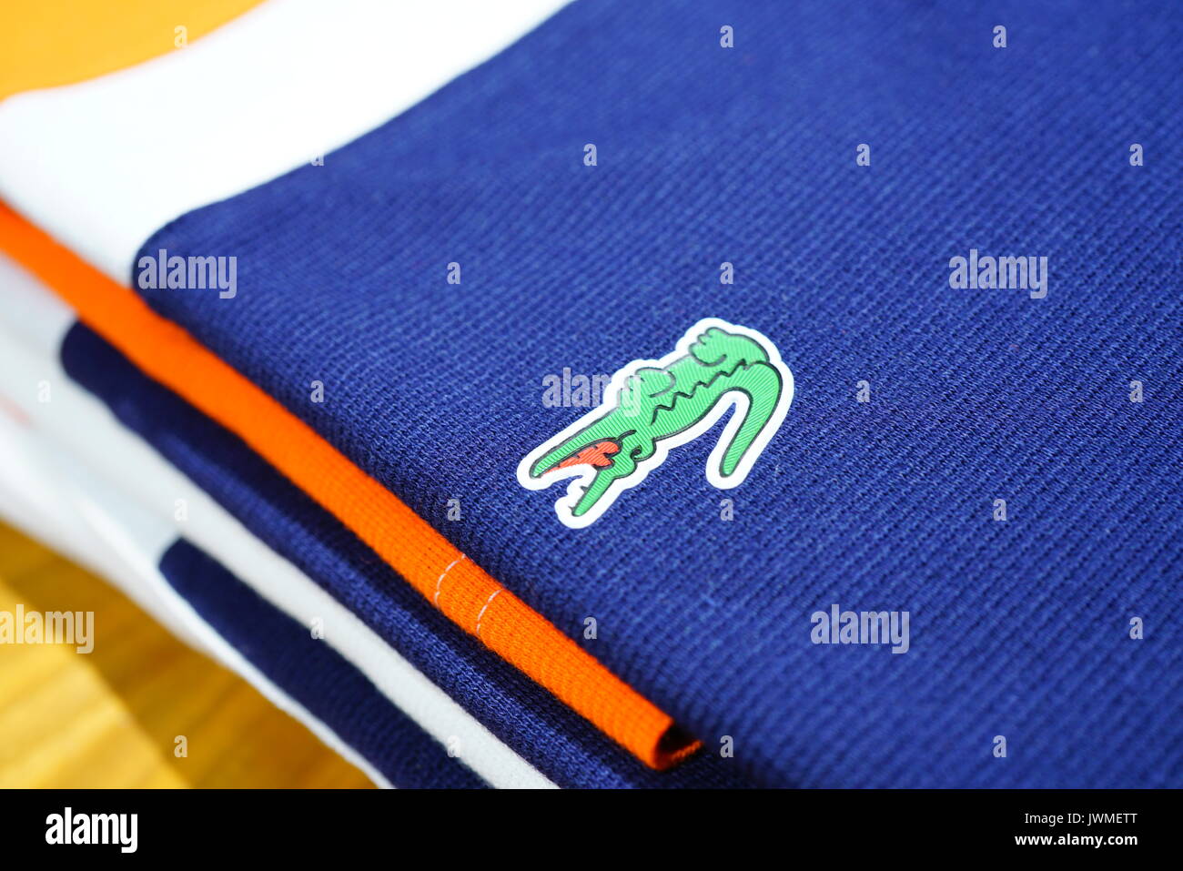 Pile di coloratissimi Lacoste magliette polo sugli scaffali del negozio. Lacoste è un abbigliamento francese azienda famosa per i suoi campi da tennis magliette. Foto Stock