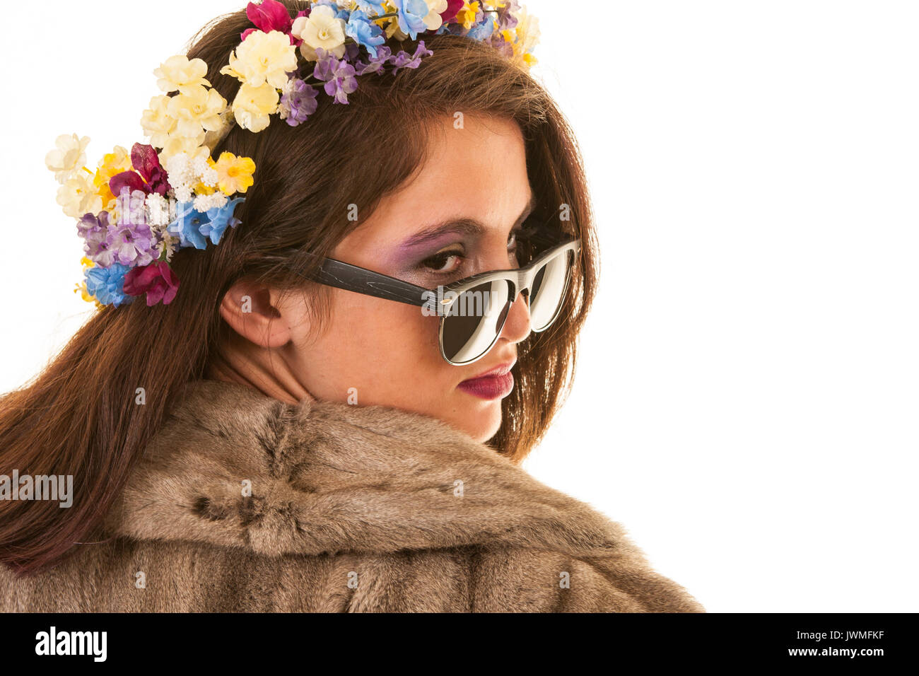 Una bella giovane ragazza adolescente con pelliccia e fiori nei suoi capelli Foto Stock