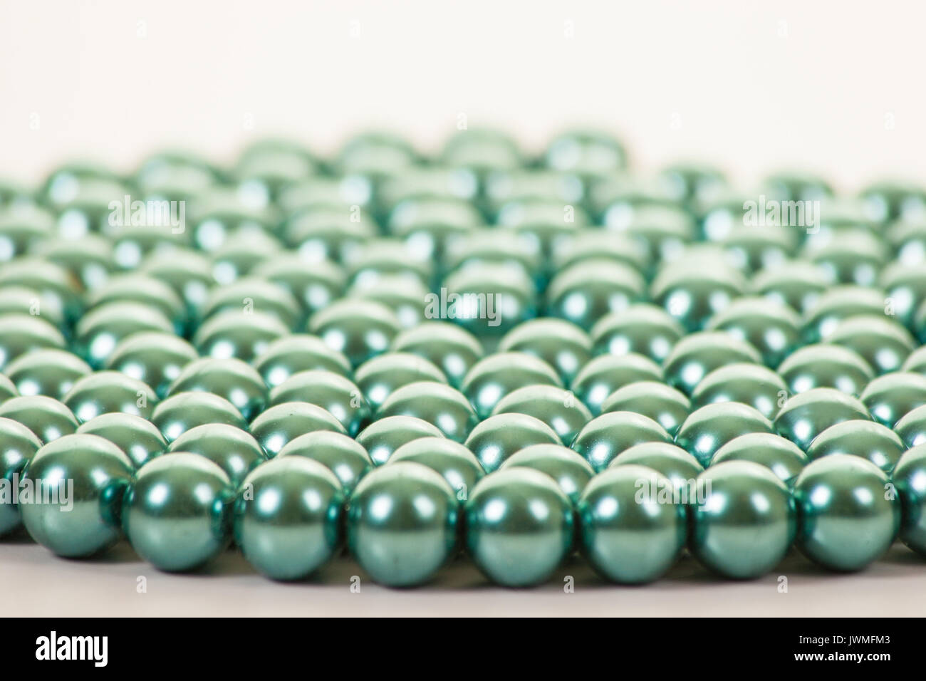 Una stringa di bella turchese perline colorate su di una superficie bianca Foto Stock