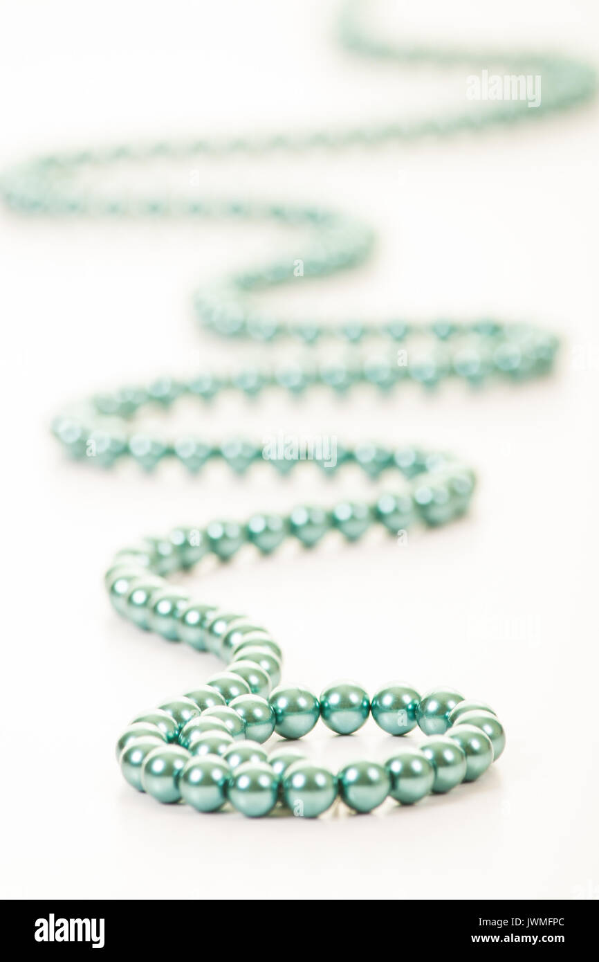 Una stringa di bella turchese perline colorate su di una superficie bianca Foto Stock